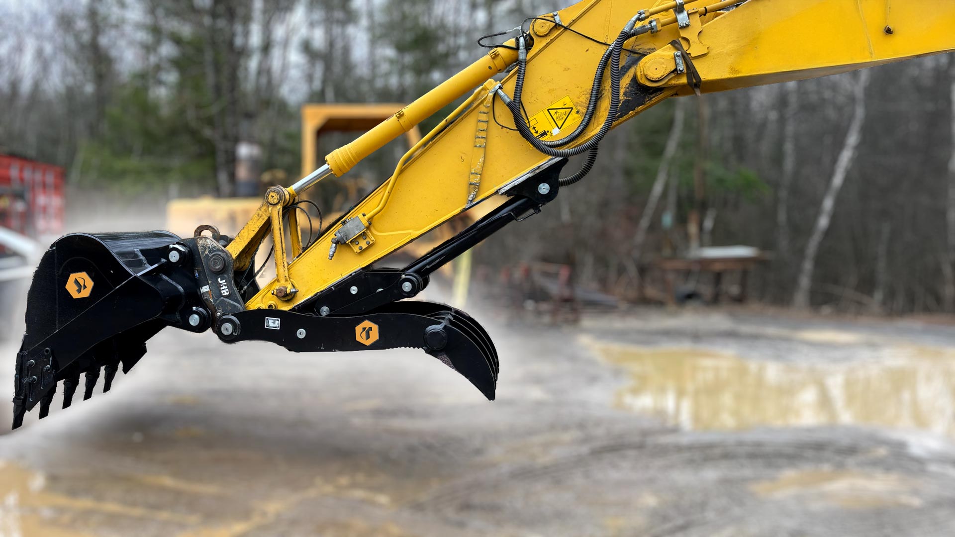 An excavator with bucket and thumb attachments.